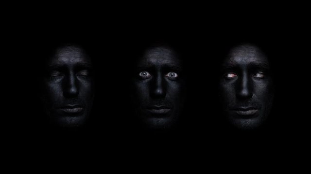 three black painted faces in black space