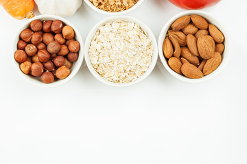 Nuts and cereals in a white ceramic dishes with vegetables