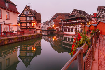 Traditional Alsatian half-timbered houses in Petite France with mirror reflections in the morning,...
