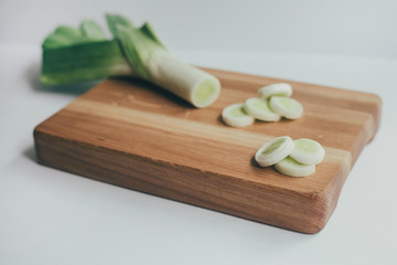 food, healthy eating and nutrition concept - sliced pumpkin and other vegetables on wooden board. Fresh vegetables and greens on a wooden board