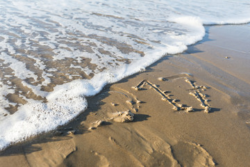 year 2017 written in the sand of the beach and erased by the waves