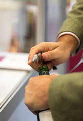 Man's Hands Opening Wine Bottle with Corkscrew