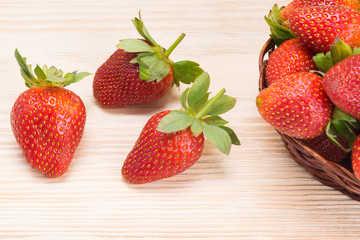 on a light wooden board in the right corner, a red strawberry, on a background