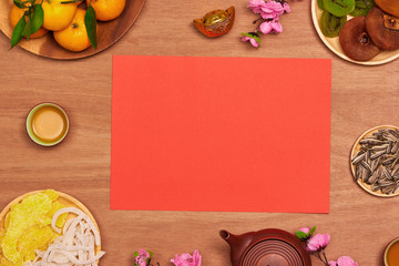 Top view accessories Chinese new year festival decorations.orange,leaf,wood basket,red packet,plum blossom on table wooden background with copy space.