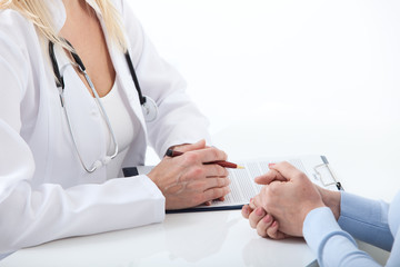 Naklejka premium Doctor and patient are discussing something, just hands at the table close up