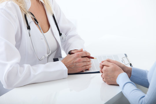 Doctor and patient are discussing something, just hands at the table close up