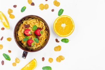 Cereal, morning breakfast, corn flakes, raisins, almonds, mint leaves, orange juice, strawberry, top view, white background, flat lay. The concept of healthy, proper nutrition, ditox.