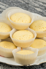 Yellow vanilla cupcakes served on the plate above grey marble