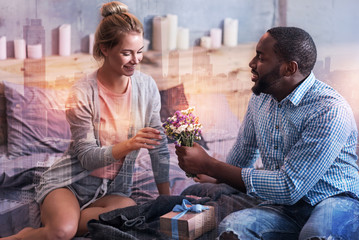 So nice. Happy delighted nice woman looking at the bouquet t and smiling while receiving a present from her boyfriend