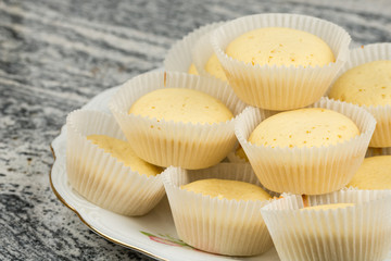 Yellow vanilla cupcakes served on the plate above grey marble