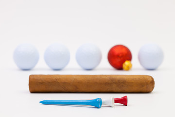 Red Christmas decoration, white golf ball and cuban cigar