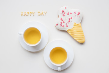 two cups of coffee on a table with cookies in the form of ice, inscription happy day