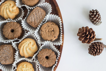 biscuits in wooden plate flat lay on white table 
