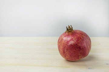 Red pomegranate on wooden table. Close up