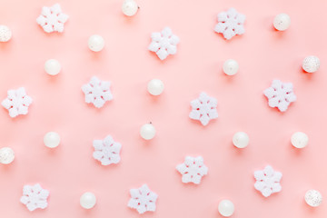 Holiday texture with white christmas snowflakes on pink background. Christmas composition, wallpaper. Flat lay, top view