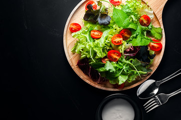 Fresh mixed vegetables salad on a wooden plate