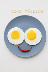 cheerful breakfast, two eggs on a plate, the inscription Good Morning