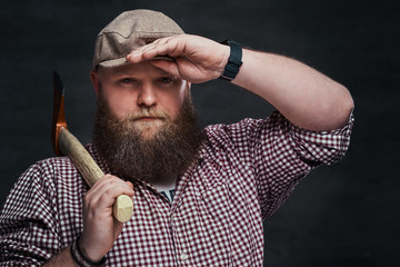 A man holds an ax on a shoulder.