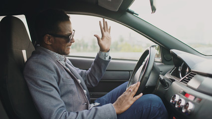 Upset and angry mixed race businessman sitting inside his car outdoors