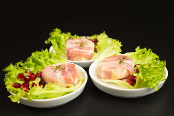goat cheese with bacon on a frisee lettuce leaf with pomegranate as garnishing