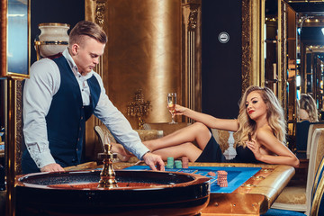 A man and woman play roulette.