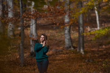 Portrait of young happy woman in casual clothes at the autumn fall forest
