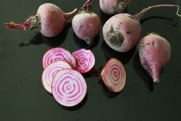 Raw chioggia beets or candy cane beets on dark background.