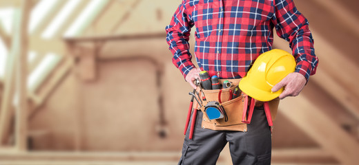 Building worker with tool belt and helmet - obrazy, fototapety, plakaty