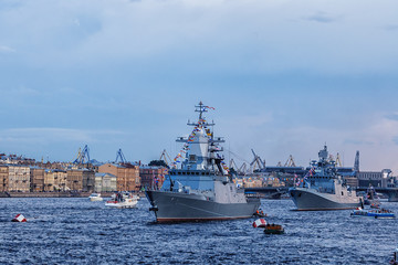 military ship on Neva river in St. Petersburg against the blue sky and the city