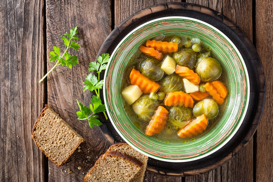 Vegetable Soup With Brussel Sprouts On Wooden Rustic Table, Top View