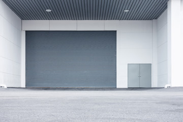 Automatic Factory Shutter Roller Door Indoor, Steel Rolling Gate Door for Security System of Warehouse Storage. Architecture Metal Access Doorway With Granite Wall Background of Workshop Store