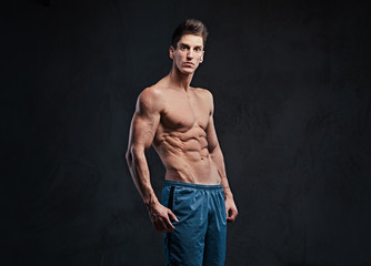 Fototapeta na wymiar Shirtless muscular male over dark background.