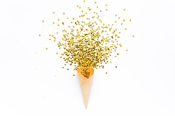 Yellow waffle cones with golden confetti tinsel isolated on white background. Flat lay, top view...