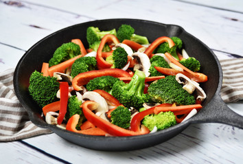 Fresh vegetables in an iron pan. Healthy eating or scene with fresh broccoli, onion, mushrooms,...