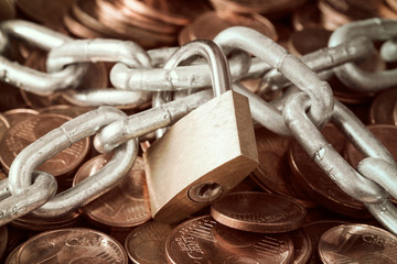 Pile of coins and a padlock with chain