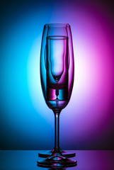 Champagne glass on color background
