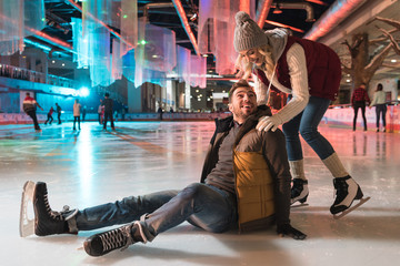 beautiful smiling young couple teaching ice skating on rink - Powered by Adobe