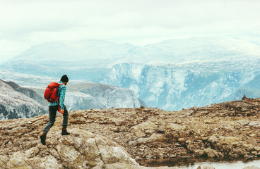 Naklejka premium Man running in mountains Travel Lifestyle concept adventure active summer vacations outdoor trekking sport with red backpack in Norway