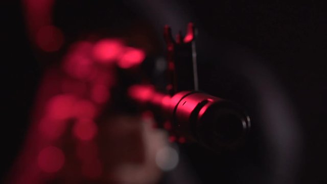 Armed man in black. Bandit with weapons in hand on a black background. The criminal scene. Hands with a gun close-up