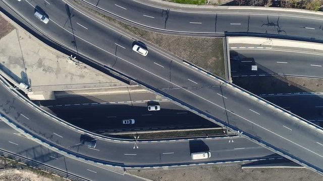 Aero shot: the concept of environmental pollution in casual megalopolis: smog, emissions, fumes on expressway with machines. The architecture of curvy autoban, many different winding turn air scene