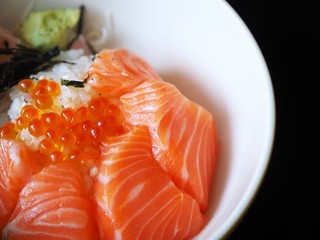 Close up Japanese rice with fresh Salmon on dark background.