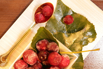frozen red cherries desert with leaves decor and gold spoon on the table