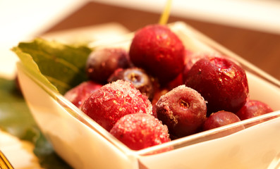 frozen red cherries desert with leaves decor and gold spoon on the table