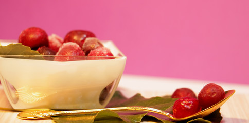 frozen red cherries desert with leaves decor and gold spoon on the table