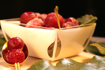 frozen red cherries desert with leaves decor and gold spoon on the table