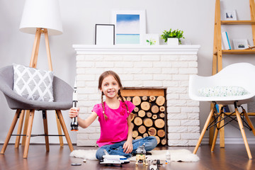 Young child girl female playing with cosmos's toys constructor: rocket, shuttle, rover, satellite...