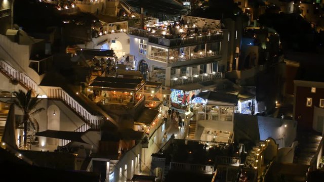 SANTORINI, GREECE – AUGUST 2016 : Video shot of Santorini cityscape at night with traditional white buildings and people in view