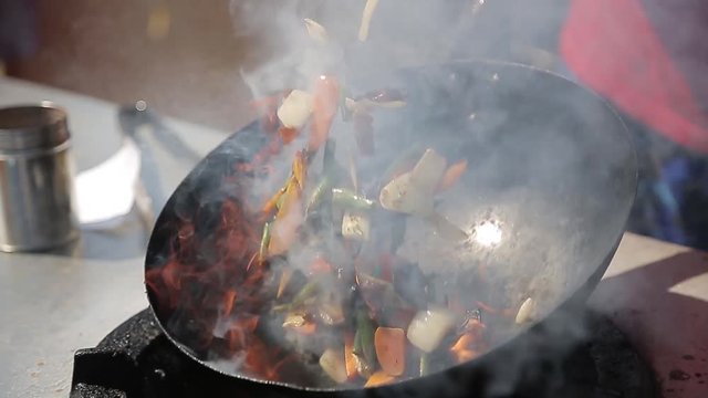 Chef Cooking With Fire In Frying Pan on a Street food Festival