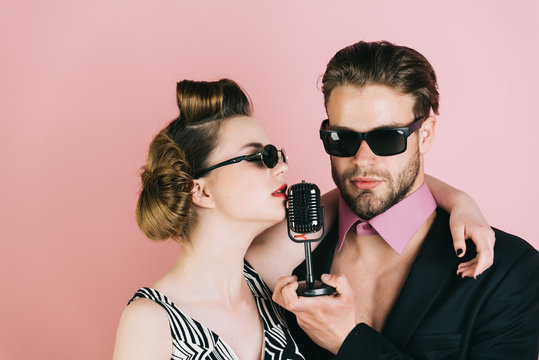 Couple in love in glasses sing in microphone.