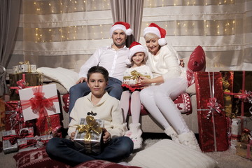 Boże Narodzenie.Rodzina na kanapie. Prezenty - obrazy, fototapety, plakaty